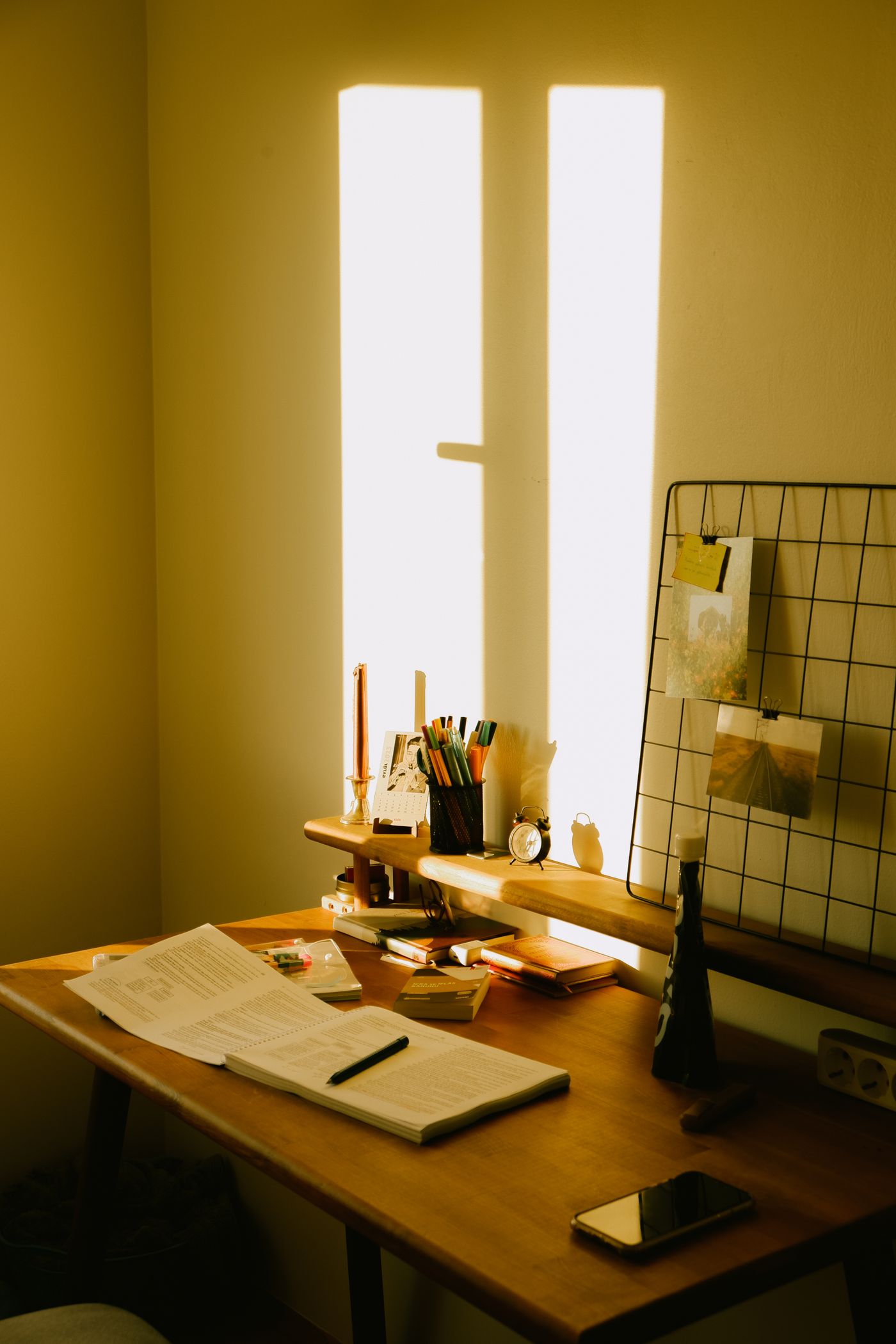 A sunlit creative workspace with an open book and stationery.